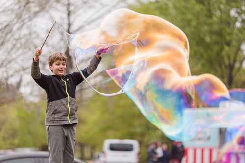 Child plays with giant bubbles at NatureFEST!