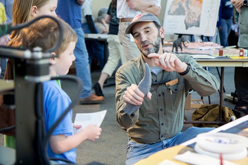 Fossil expert points out features of a fossil to a child