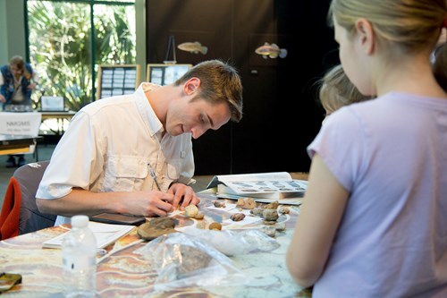 A fossil expert giving a demonstration to children at the Fossil Road Show