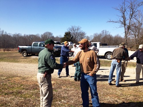 A landowner and a fire professional shake hands after a Fire on the Forty workshop