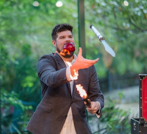 Todd Smith Magic show at NatureFEST; man throws a knife while holding a flaming torch