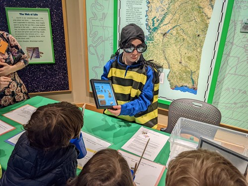 Exhibitor in a bee costume shares information with kids on Pollinator Day