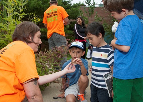 Children examine a plant with help from an expert