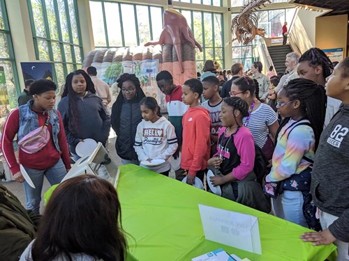 STEM, Leaves, and Trees Event - Engaged group of students at exhibitor table