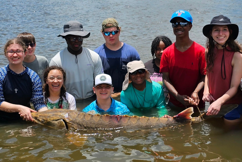 mmns summer campers in water with fish