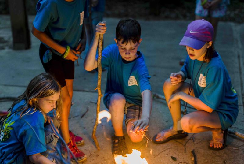 mmns summer campers roasting marshmallows at night campfire